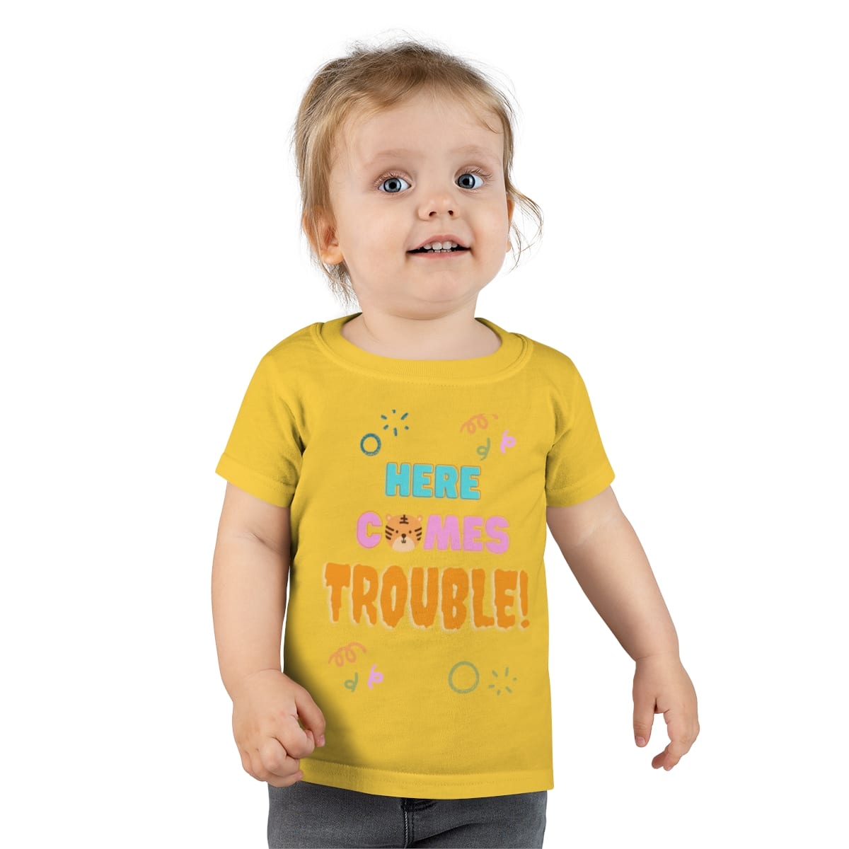 Child wearing a yellow Here Comes Trouble T-shirt from Human Kind Media